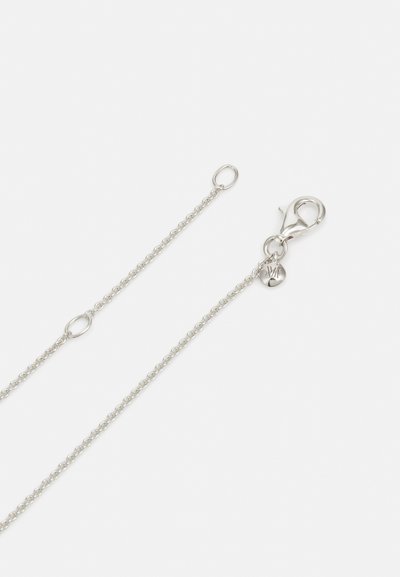 Cadena de metal plateado con pequeños eslabones entrelazados, que presenta un cierre de langosta y una etiqueta redonda grabada. Textura suave, diseño minimalista.