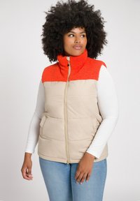 Gilet imbottito con una parte inferiore beige e una parte superiore in tessuto testurizzato arancione brillante. Presenta un colletto alto e una chiusura con zip.