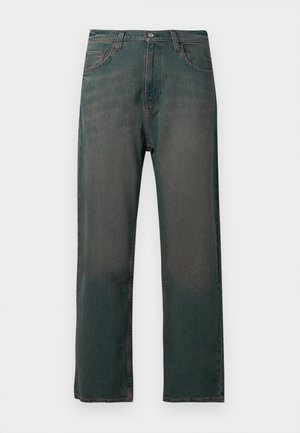 Sötétzöld farmernadrág egyenes szárú szabással, klasszikus öt zsebes kialakítással és kontrasztos varrással a varratok mentén.