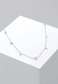 Sølv kædedesigns med runde og stjerneformede accenter, prydet med klare ædelsten. Delikat design med en glat tekstur.