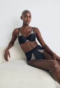 Black lingerie set featuring a padded bra with lace detailing on the cups and high-waisted briefs with lace accents. Smooth texture, seamless design.