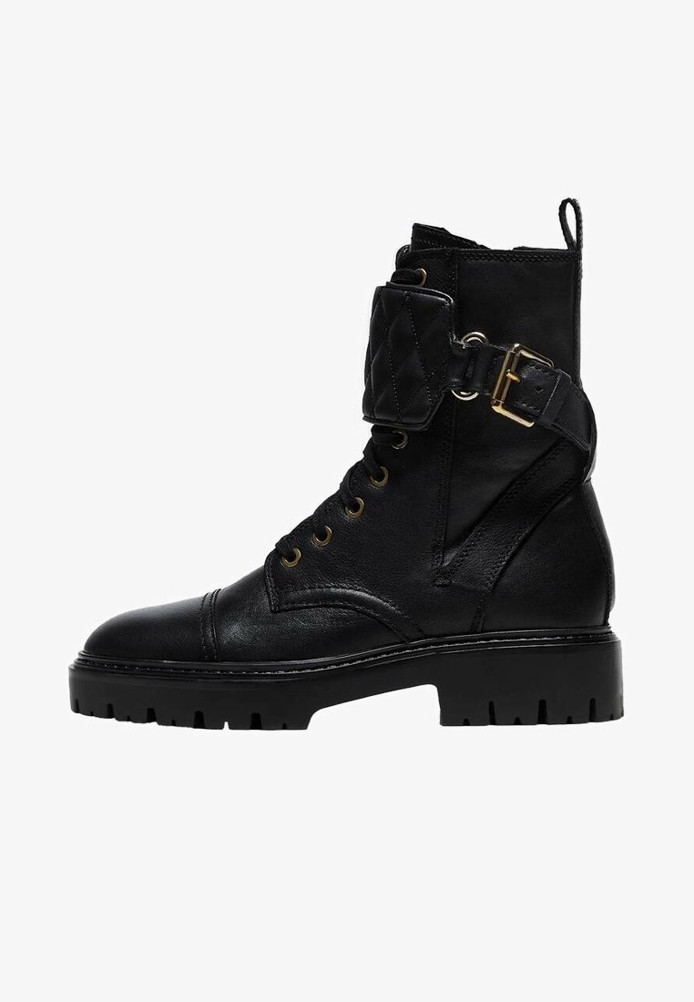 Botte de combat en cuir noir avec laçage à l'avant, bride matelassée à la cheville avec boucle dorée, languette d'extraction et semelle épaisse crantée.