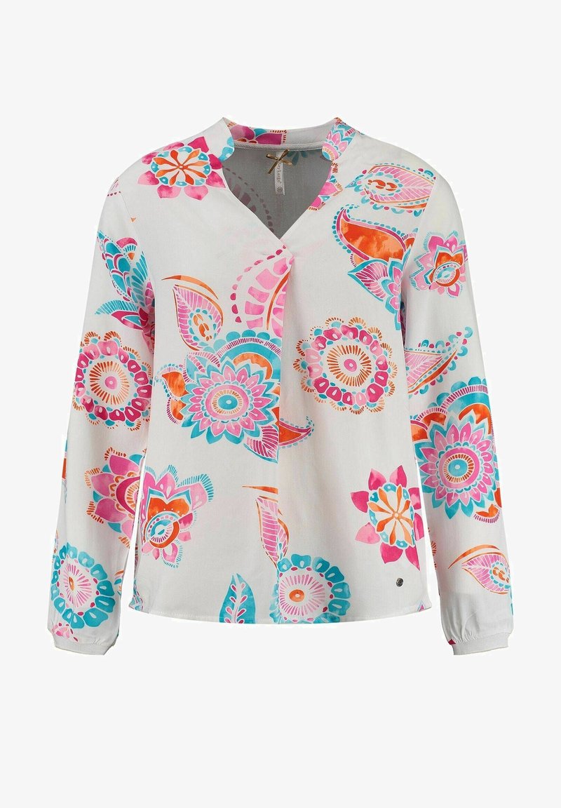 Blouse blanche à manches longues avec des motifs floraux vibrants en rose, orange et turquoise, et un col en V arrondi.