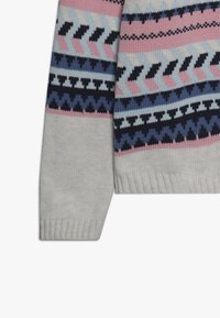 Neulepuseron hiha, jossa on geometrisia kuvioita mustassa, vaaleanpunaisessa, sinisessä ja valkoisessa kevyellä harmaalla kankaalla, jossa on ribbireuna.