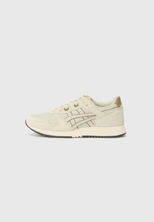 Une paire de baskets basses beige avec une tige en mesh et daim, des bandes latérales décoratives, une fermeture à lacets et une semelle en caoutchouc clair sur fond uni.