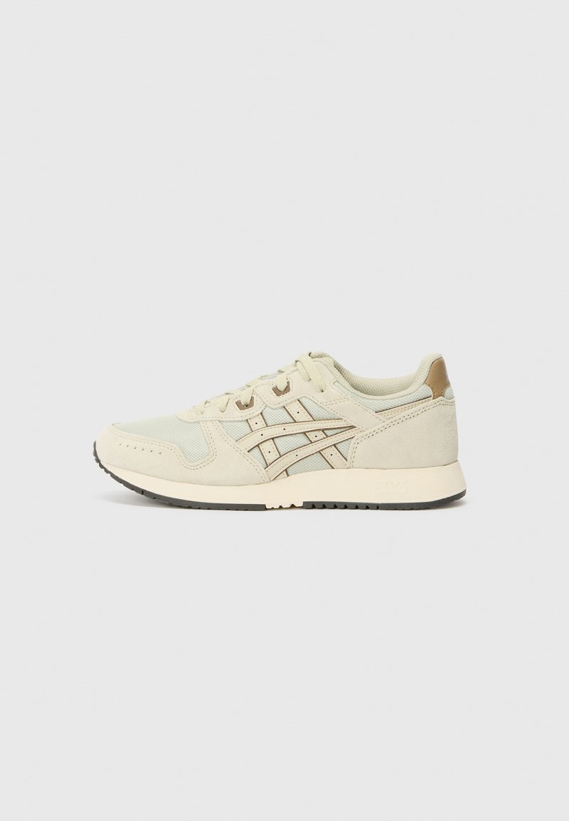 Une paire de baskets basses beige avec une tige en mesh et daim, des bandes latérales décoratives, une fermeture à lacets et une semelle en caoutchouc clair sur fond uni.