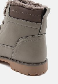 Gray suede ankle boot with a textured brown fabric collar, padded interior, and a durable brown rubber sole featuring a lug pattern.