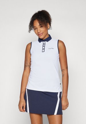 Sleeveless polo in white with navy collar and accents. Features a button placket and logo on the chest. Paired with dark skirt with side stripes.
