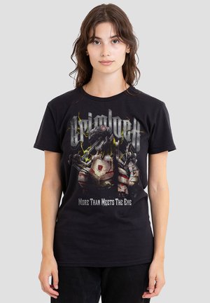 Black cotton t-shirt featuring a graphic print of a robotic figure with the text "Grimlock" and "More Than Meets The Eye" in bold letters.