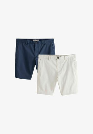 Kaks paari meeste kohandatud lühkse, üks tumesinine ja üks beež, mõlemal ees taskud ja vööaasad, valgel taustal eksponeeritud.