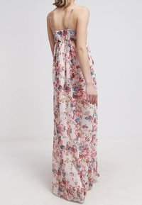 Robe longue en tissu léger à motifs floraux avec bretelles fines, dos froncé et couleurs vives incluant le rose, le bleu et le vert.