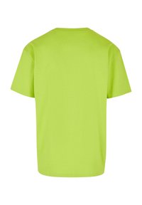 T-shirt a maniche corte in cotone verde lime brillante con collo rotondo e design semplice; presenta una vestibilità ampia senza alcun motivo o accento.