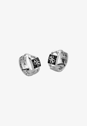 Silberne Creolen mit schwarzen quadratischen Anhängern, die ein ineinandergreifendes weißes Logo und ein Kettenglied-Design auf den Bändern zeigen.