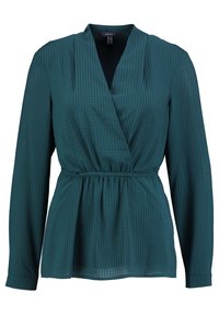 Tealblus med en omslagsdesign, långa ärmar och en rynkad midja. Har ett strukturerat rutmönster och en V-ringning.