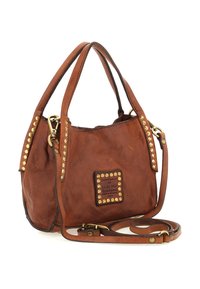 Borsa a tracolla in pelle marrone con borchie dorate, due manici e una tracolla regolabile, poggiata accanto su uno sfondo bianco.