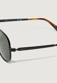 Occhiali da sole Ray-Ban neri con lenti grigio scuro, montatura in metallo e dettagli tartarugati sulle tempie. Presentano un design classico e linee eleganti.