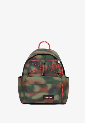 Mochila con patrón de camuflaje fabricada en un tejido duradero. Presenta detalles en rojo, diseño de cordón elástico y bolsillo frontal con cremallera.