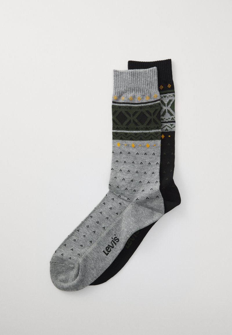 Δύο ζεύγη patterned κάλτσες crew, μία γκρίζα με μαύρες και κίτρινες λεπτομέρειες, μία μαύρη με γκρίζες και κίτρινες πινελιές, τοποθετημένα επίπεδα σε άσπρο φόντο.