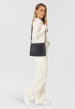 Bolso cruzado de cuero negro con un acabado texturizado, forma rectangular y correa ajustable con detalles de cadena.