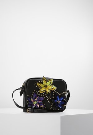 Bolso bandolera negro decorado con tres grandes flores de lentejuelas en amarillo, morado y azul, adornado con pequeñas tachuelas doradas.