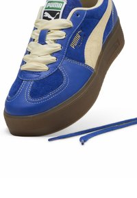 Adidași din suede și piele albastr�ă cu accente bej, vârf rotund, talpă groasă maro și șireturi crem. Include o pereche suplimentară de șireturi albastre.