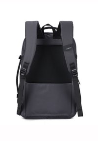 Sac à dos gris avec des bretelles rembourrées, un panneau arrière en mesh et une poche avant. Fabriqué en tissu durable, présentant un design minimaliste.