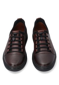 Brązowe skórzane buty wsuwane z elastycznymi sznurówkami, okrągłym noskiem i czarną gumową podeszwą. Cechuje je gładkie wykończenie i minimalistyczny design.