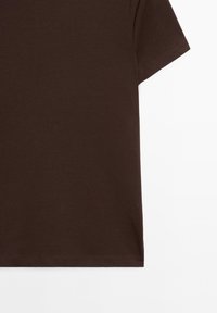 Maglietta a maniche corte di colore marrone scuro, semplice, con cuciture visibili sulle maniche e sull'orlo, mostrata su uno sfondo bianco.