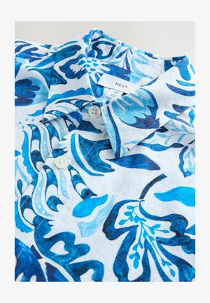 Short-sleeve shirt featuring a blue floral pattern on a white background, with a textured fabric and two button closures at the collar.