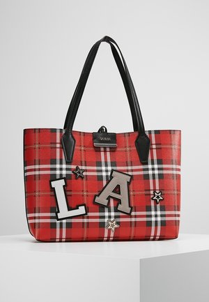 Sac fourre-tout en tartan rouge avec des poignées noires, décoré de grandes patchs "L" et "A" ainsi que de petites appliques en forme d'étoiles, marqué "Guess" en haut.