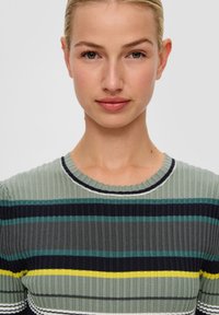 Geribbeld gebreid top met horizontale strepen in groen, marineblauw, teal en geel. Rondhals ontwerp met contrasterende afwerkingsdetails.