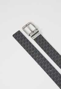 Cintura grigia con motivo in tessuto, dotata di una fibbia metallica rettangolare argentata. Presenta diversi fori per le regolazioni della misura.