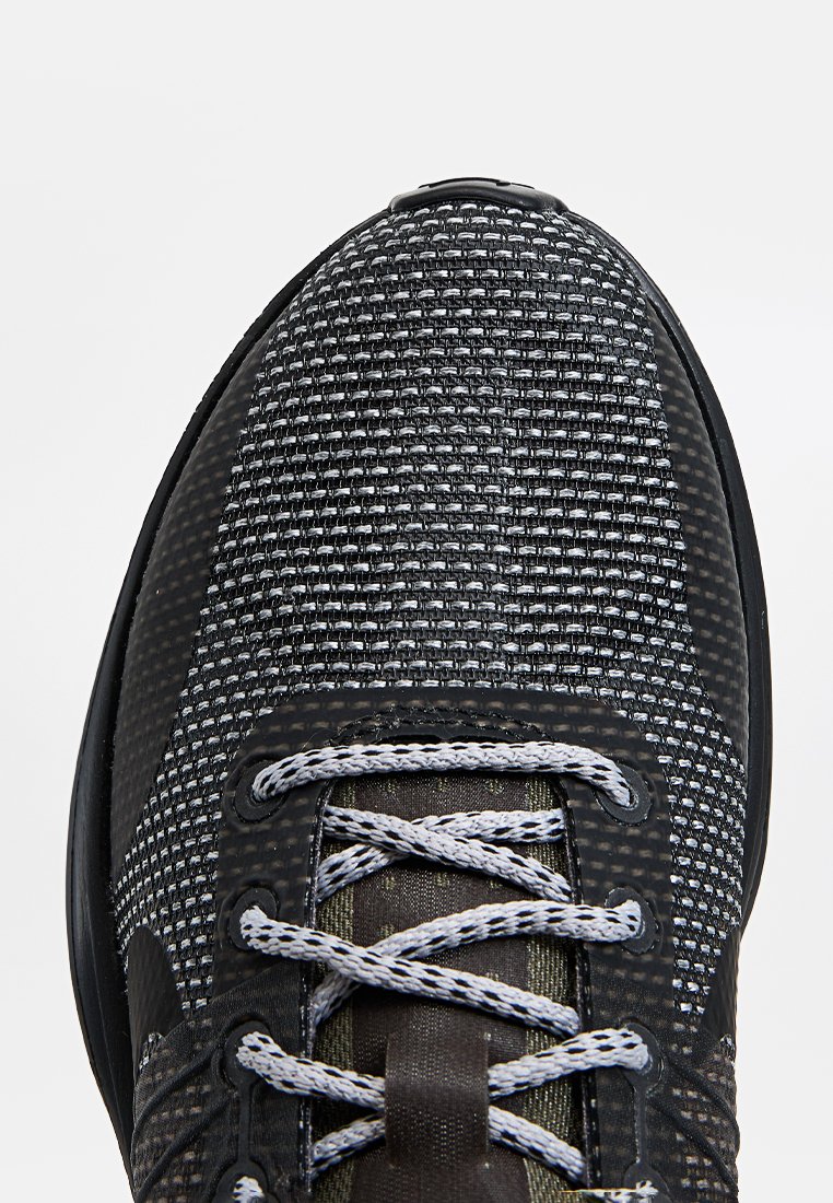 Schwarze und graue Sportschuhe mit einem strukturierten Mesh-Obermaterial, runder Zehenpartie und grauen Schnürsenkeln. Verfügt über verstärkte Ösen und eine strapazierfähige Gummisohle.