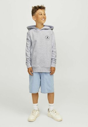 Haut à capuche gris avec une poche frontale et un logo graphique noir, associé à un short en denim bleu clair et des baskets blanches. Design simple et coupe décontractée.