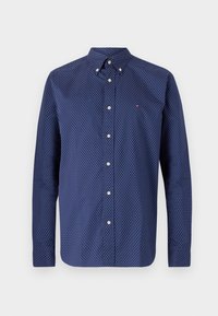 Navyblauw shirt met witte stippen, lange mouwen, button-down kraag en knoopsluiting aan de voorkant. Klein logo op de borst.