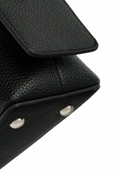 Borsa a mano nera in pelle con una superficie testurizzata, patta superiore triangolare curvata e dettagli in metallo argentato vicino alla base.