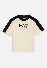 Tej anyagú, krémszínű póló fekete raglán ujjal, melyen az "EA7 Emporio Armani" logó fekete és ezüst hímzéssel látható. Szokásos környakú fazon.