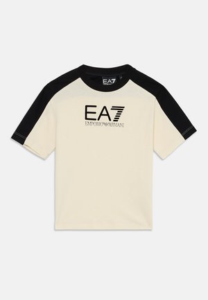 Cremefarbener Baumwoll-T-Shirt mit schwarzen Raglanärmeln, versehen mit dem "EA7 Emporio Armani"-Logo in schwarzem und silbernem Stick. Klassischer Rundhalsausschnitt.