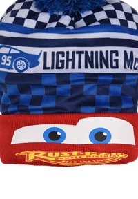 Beanie made of knit fabric with blue and red sections. Features checkered pattern and cartoon character design with blue pom-pom on top.