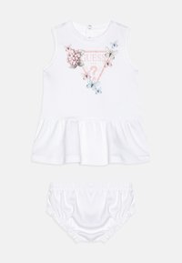 Rochie albă fără mâneci, cu tiv ondulat, decorată cu imprimeuri florale și cu fluturi, asortată cu pantaloni scurți albaștri cu talie elastică.