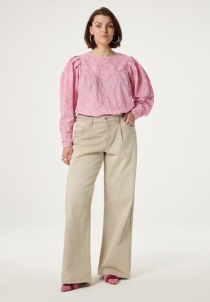 Roze gestructureerde blouse met opgeblazen mouwen, gecombineerd met lichtbeige wijde broek en roze schoenen. Eenvoudig ontwerp, minimale accenten.