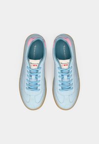 Ανοιχτό μπλε αθλητικά με λεία υφή, ροζ λεπτομέρειες στην φτέρνα και μπλε κορδόνια. Διαθέτουν καουτσούκ σόλα και ραφή σχεδίου.