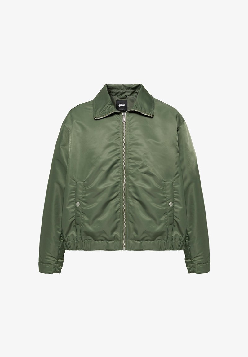 Veste verte zippée avec col, taille élastique et poches latérales à boutons-pression, présentée sur fond blanc.