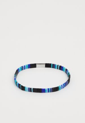 Bracelet en perles dans des teintes de bleu, noir et turquoise, comportant un mélange de perles rectangulaires et cylindriques avec un fermoir métallique.