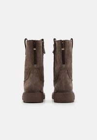 Brown suede ankle boots with dual zippers on the sides, sturdy rubber soles, and pull tabs at the back for easy wear.