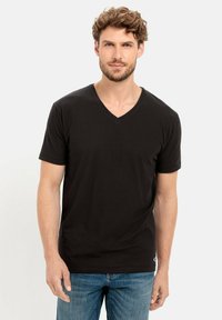 Zwarte kortgebreide V-hals T-shirt van zachte stof, met een getailleerde silhouet en een klein logo-accent aan de onderrand.