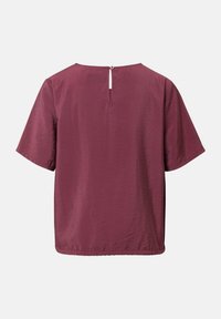 Blusa bordeaux a maniche corte con scollatura tonda, tessuto testurizzato e chiusura sul retro con un piccolo bottone e dettaglio a forma di chiave.