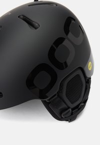 Fekete sisak matt felülettel, szellőzőnyílásokkal és nagy fényes logókkal. Állítható pántokkal és hálós párnázási részletekkel rendelkezik.