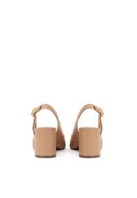 Beige kiiltävästä nahasta valmistetut paksupohjaiset sandaalit, joissa on nilkkahihna ja kultainen solki. Sandaaleissa on sileä pinta ja pyöreä kärki.