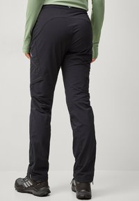 Sort udendørsbukser med en tætsiddende design, der har sidelommer, en strækbar talje og en slank, let tekstur i stoffet.